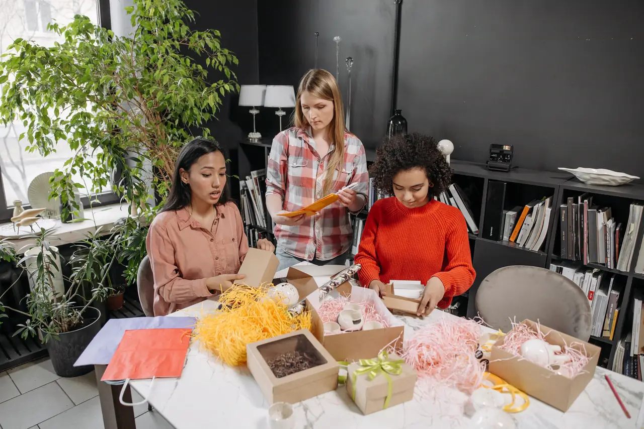 Small team works together on product packaging at a shared table